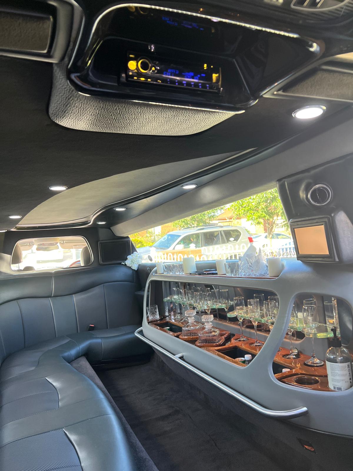 Luxe Line Limos limousine cabin showing leather bench seating and glassware bar